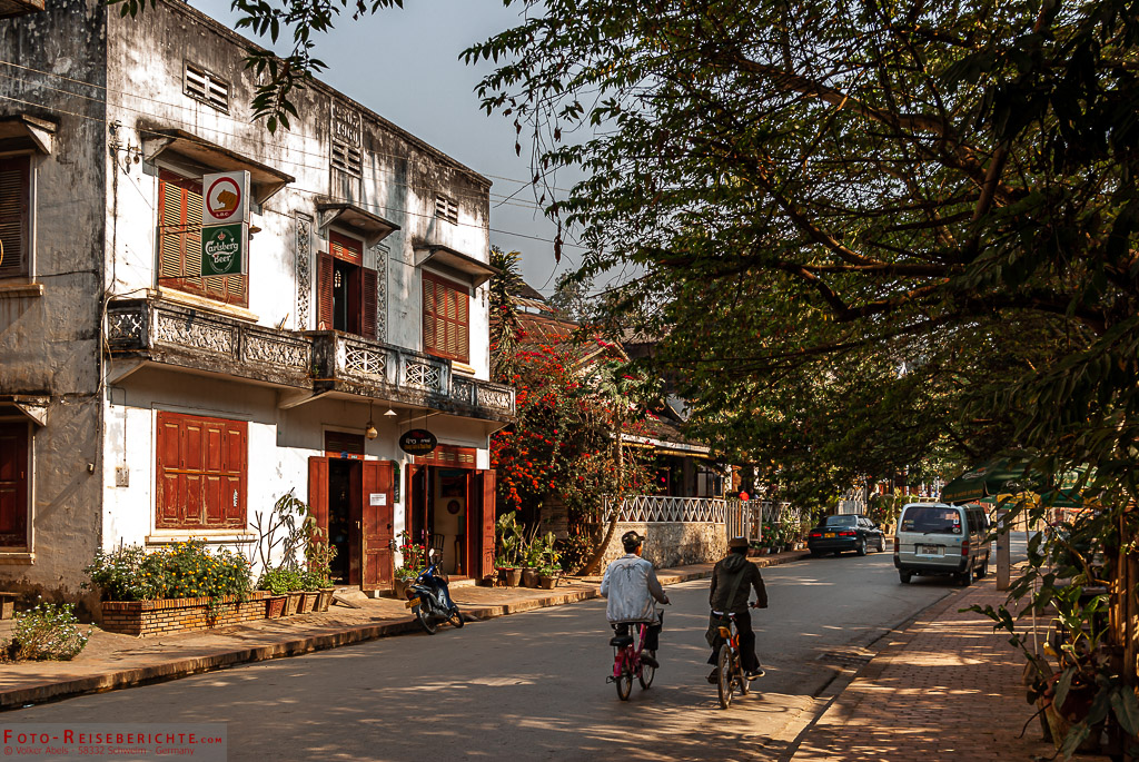 Zwei Radfahrer in einer Seitenstraße in Luang-Prabang Seitenstraße in Luang Prabang